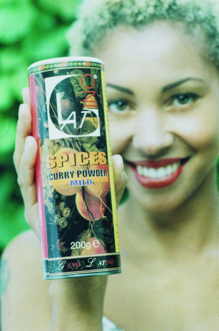 Woman holding a tin of Gino Latino mild curry powder