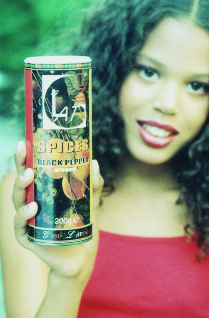 Woman holding a tin of Gino Latino ground black pepper